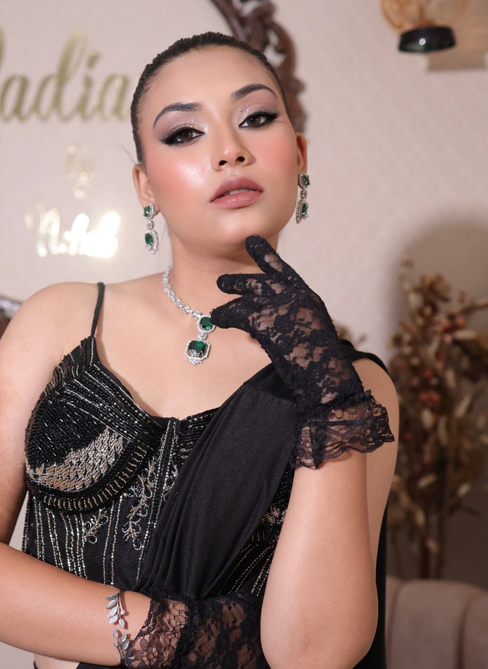 Black corset saree with smokey eyes and emerald jewellery