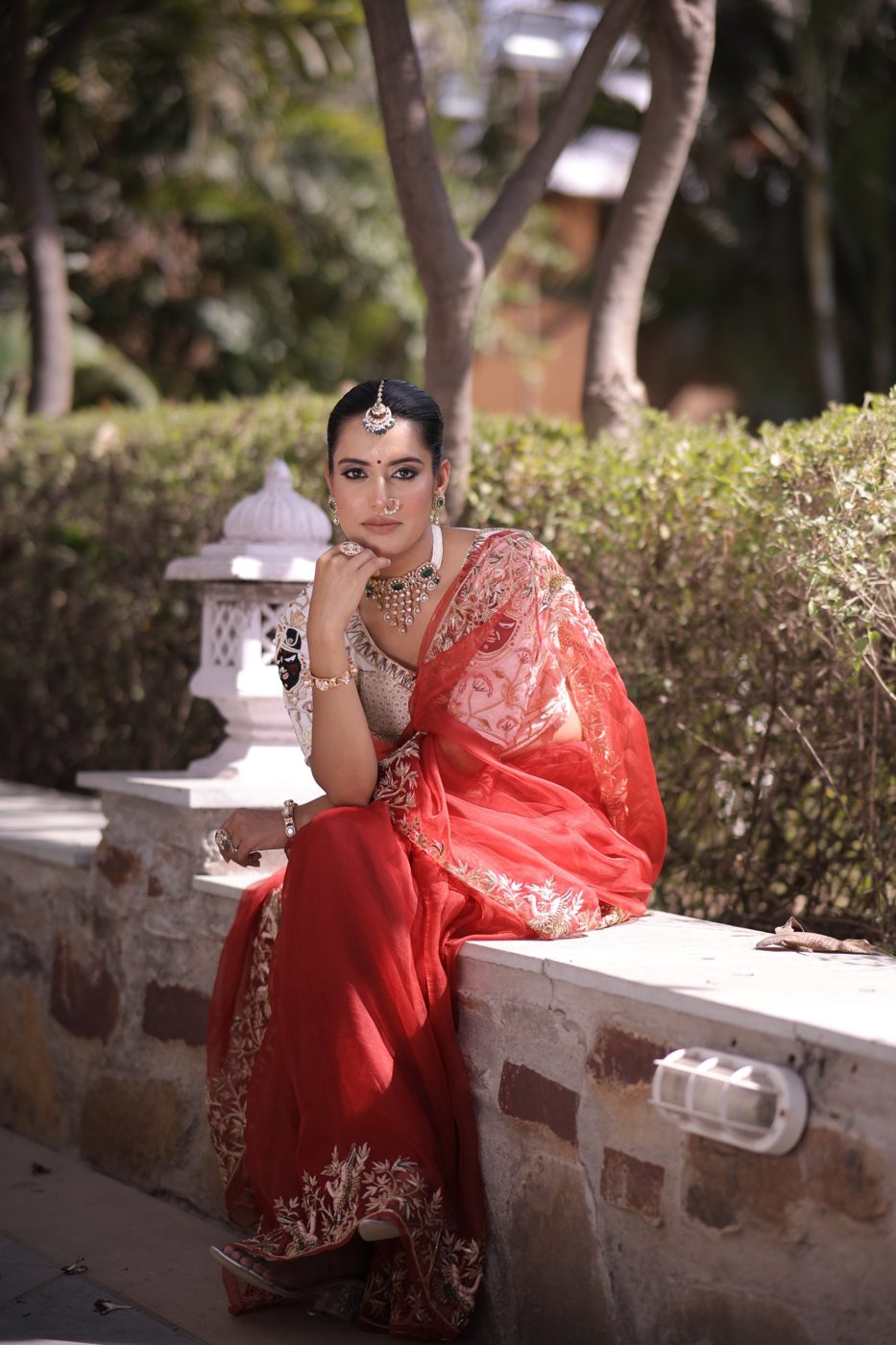 Red organza saree look photographed outdoors